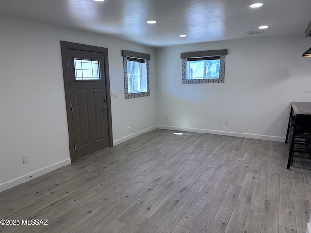 entrance foyer featuring wood finished floors, visible vents, and baseboards