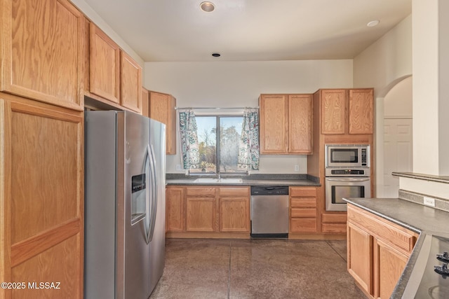 kitchen featuring a sink, dark countertops, and stainless steel appliances