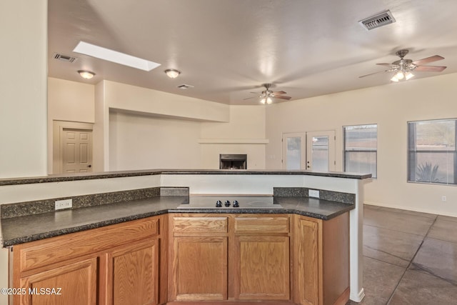 kitchen with open floor plan, a skylight, visible vents, and ceiling fan