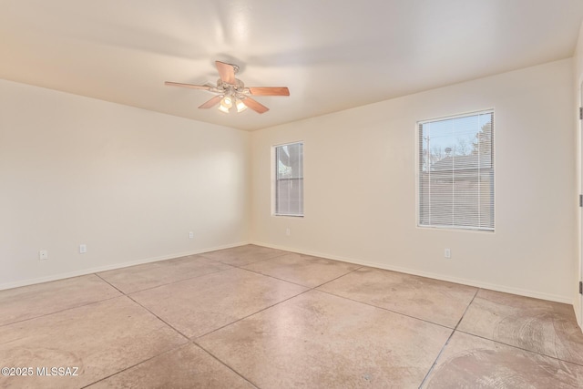 unfurnished room featuring baseboards, concrete flooring, and a ceiling fan