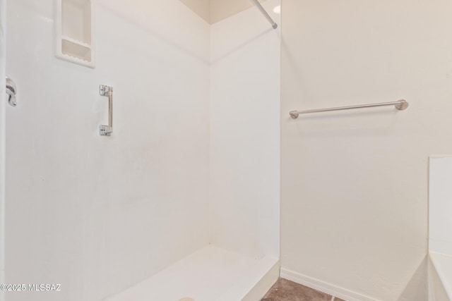 full bath featuring baseboards and walk in shower