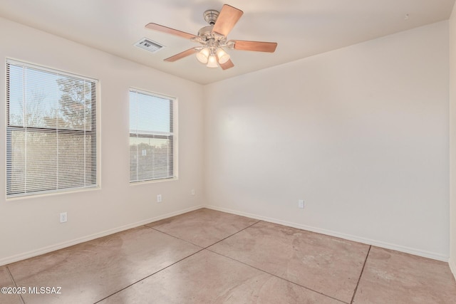 empty room with visible vents, a ceiling fan, concrete floors, and baseboards