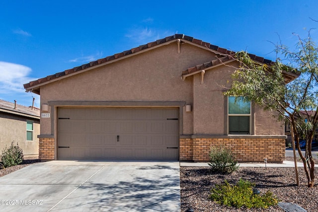 view of front of property featuring brick siding, stucco siding, an attached garage, and concrete driveway