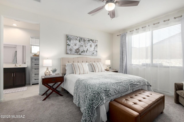 bedroom featuring ceiling fan, light tile patterned floors, light colored carpet, and a sink