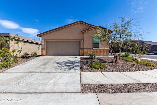 view of front of house with brick siding, stucco siding, driveway, and a garage