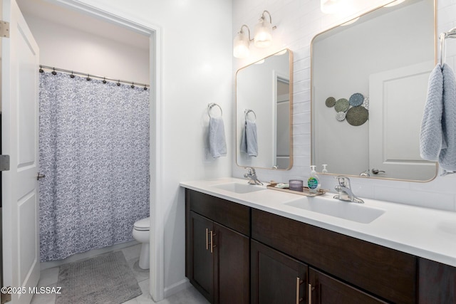 bathroom featuring a sink, toilet, and double vanity