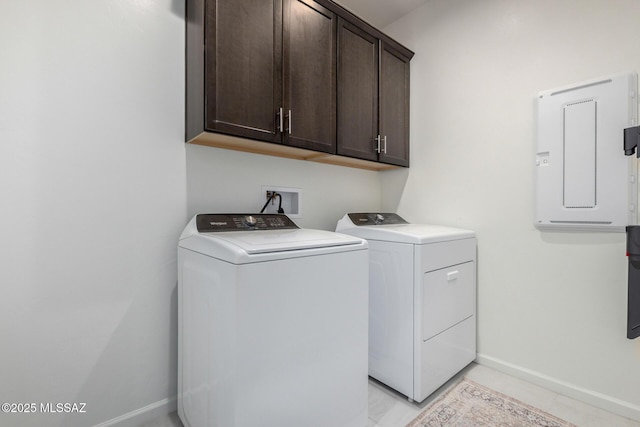 laundry room with electric panel, cabinet space, baseboards, and separate washer and dryer