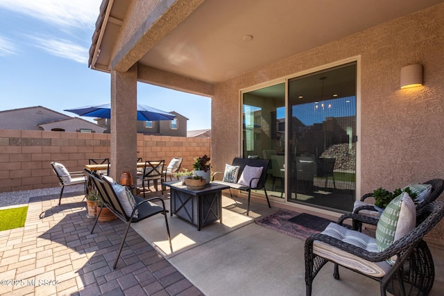 view of patio featuring outdoor lounge area and fence