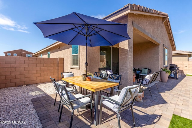 view of patio featuring area for grilling, outdoor dining area, and fence