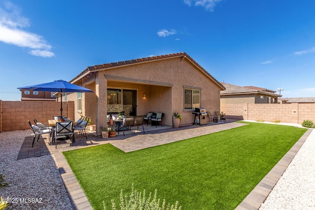 rear view of property with a patio, a yard, a fenced backyard, stucco siding, and an outdoor hangout area