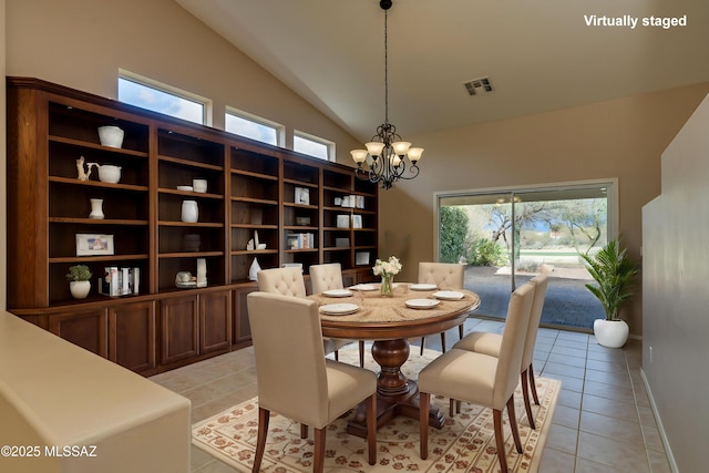dining space with visible vents, baseboards, vaulted ceiling, light tile patterned floors, and an inviting chandelier