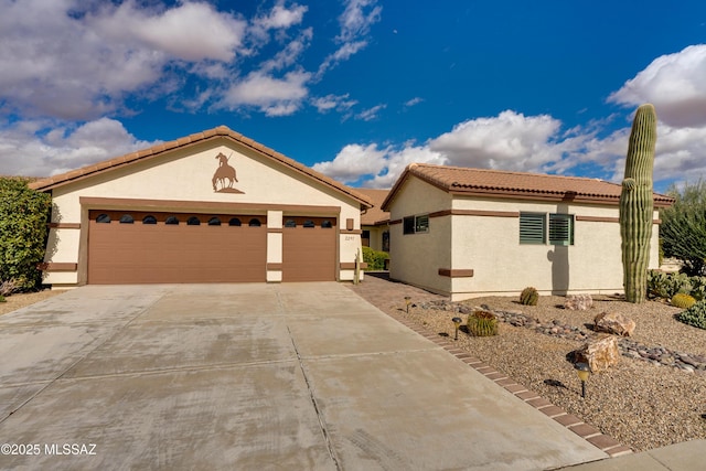 mediterranean / spanish-style home with a tiled roof, an attached garage, driveway, and stucco siding