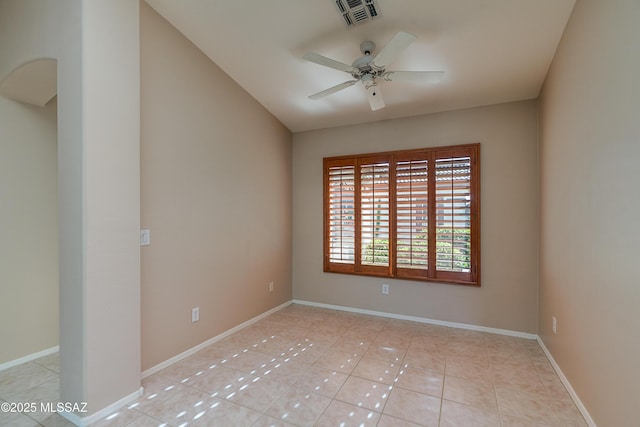 unfurnished room featuring light tile patterned floors, visible vents, baseboards, and a ceiling fan