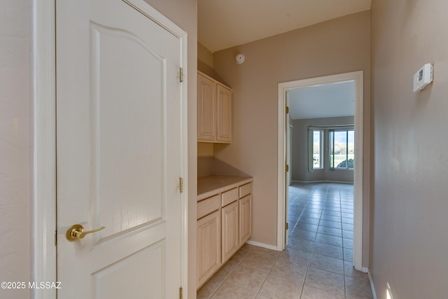 hallway with light tile patterned floors and baseboards