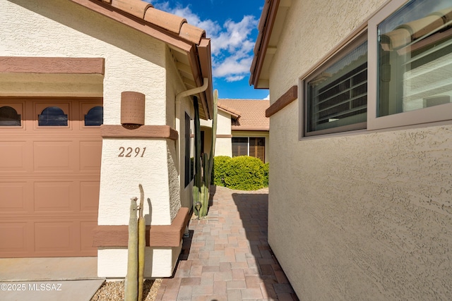 view of home's exterior with stucco siding and a garage