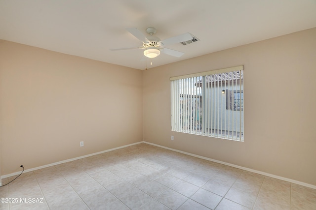 unfurnished room with light tile patterned floors, visible vents, baseboards, and a ceiling fan