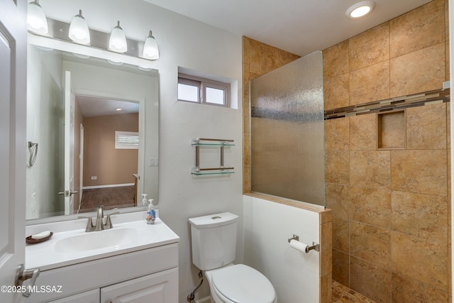 bathroom featuring toilet, vanity, and a walk in shower