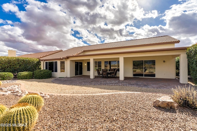 back of house with a patio, a tiled roof, and stucco siding