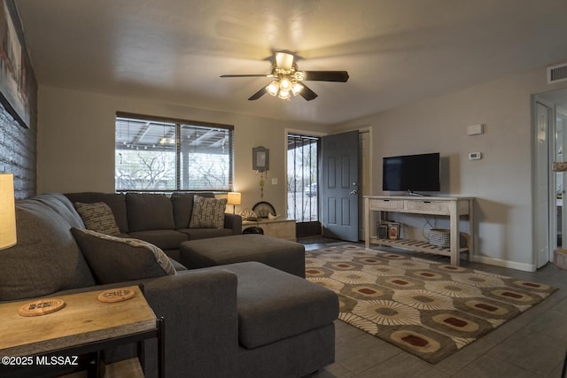 tiled living area featuring baseboards and ceiling fan