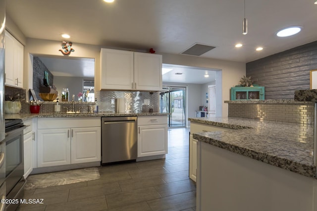 kitchen featuring a sink, stainless steel appliances, backsplash, and white cabinetry