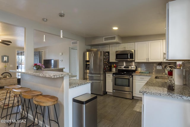 kitchen with a sink, decorative backsplash, visible vents, and stainless steel appliances