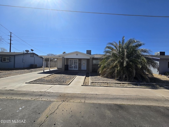 view of front of home featuring french doors, a carport, and concrete driveway