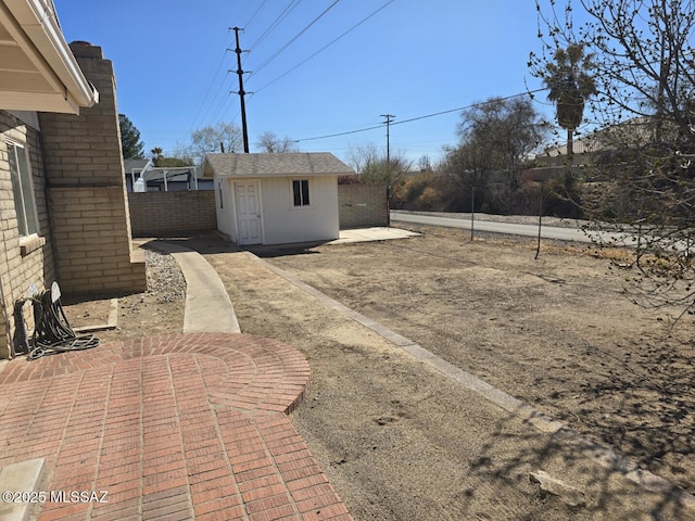 view of yard featuring a patio area, an outdoor structure, and fence