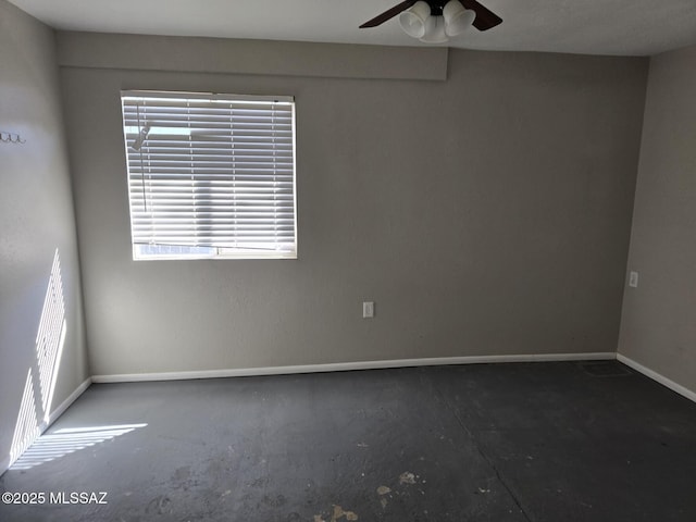 spare room featuring baseboards and a ceiling fan