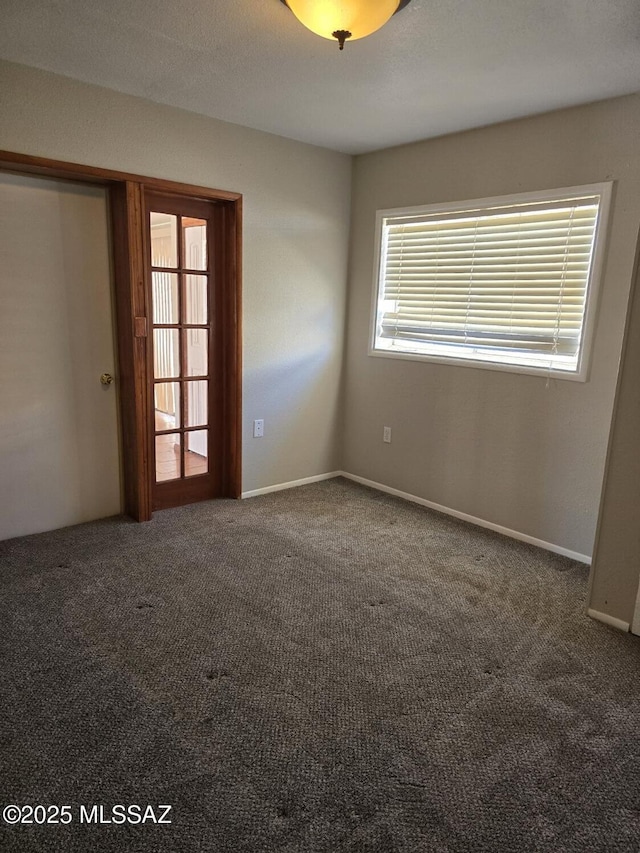 carpeted spare room featuring baseboards