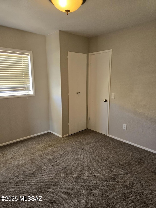 unfurnished bedroom with baseboards and carpet floors