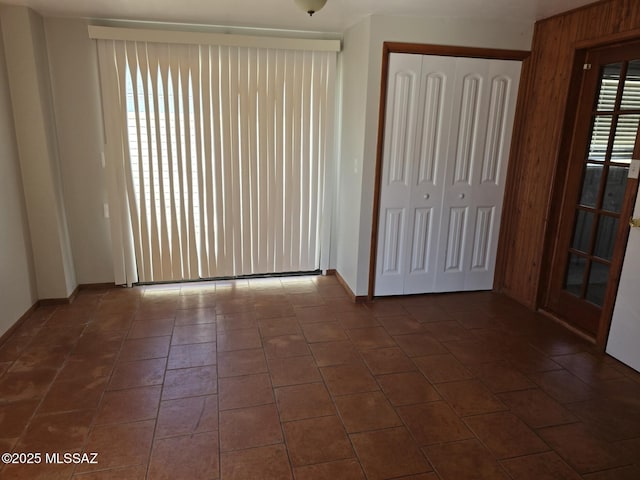 interior space featuring dark tile patterned floors, baseboards, and a closet