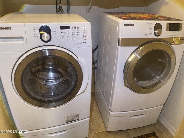 clothes washing area featuring separate washer and dryer, tile patterned flooring, and laundry area