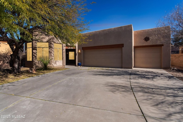 southwest-style home featuring stucco siding, concrete driveway, and a garage