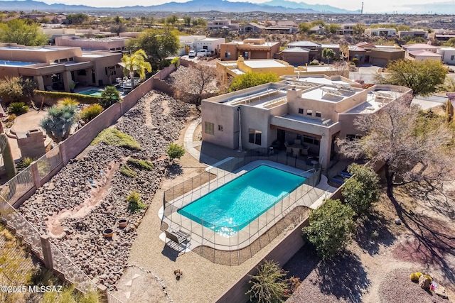 view of swimming pool with a residential view, a mountain view, a fenced in pool, and a fenced backyard