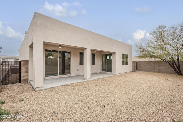 back of house featuring stucco siding, a patio, a fenced backyard, and a ceiling fan