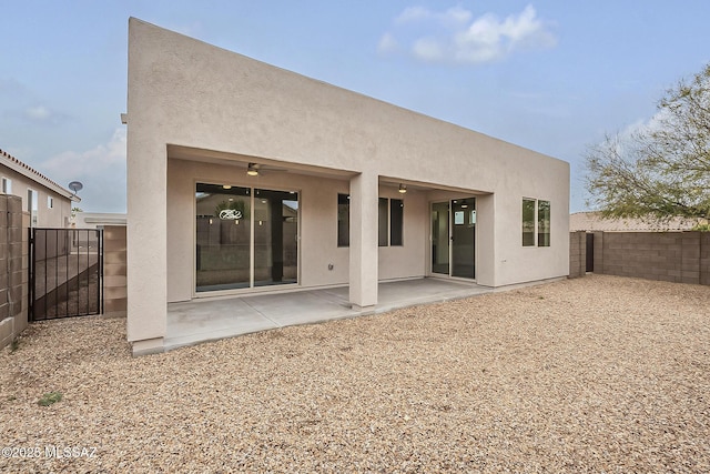 back of house featuring stucco siding, a patio, and a fenced backyard