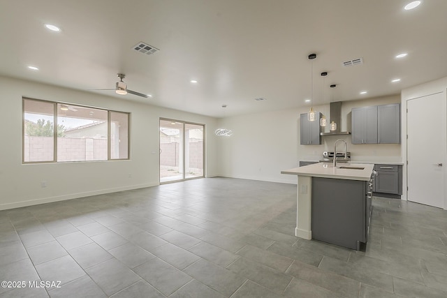 kitchen with visible vents, gray cabinetry, a ceiling fan, a sink, and light countertops