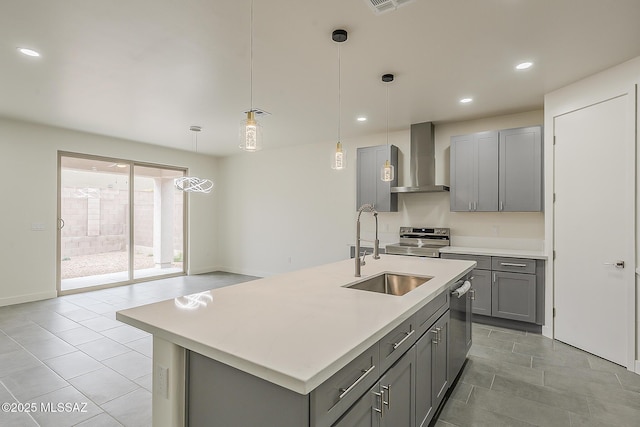 kitchen featuring gray cabinets, stainless steel appliances, wall chimney range hood, and a sink