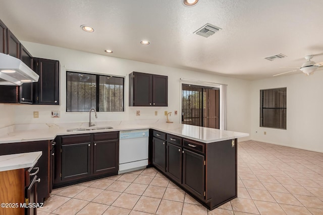 kitchen with a sink, visible vents, a peninsula, and white dishwasher