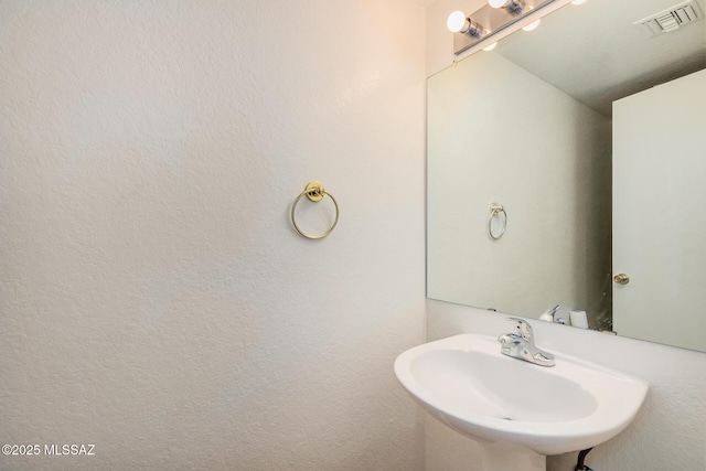 bathroom featuring visible vents and a sink