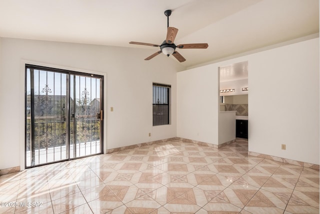 spare room featuring baseboards, ceiling fan, and vaulted ceiling