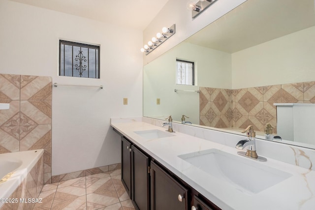 bathroom with a sink, tiled tub, and double vanity