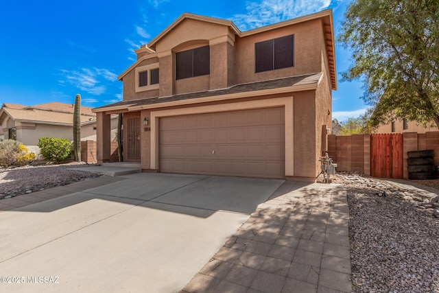 traditional-style home featuring concrete driveway, fence, a garage, and stucco siding