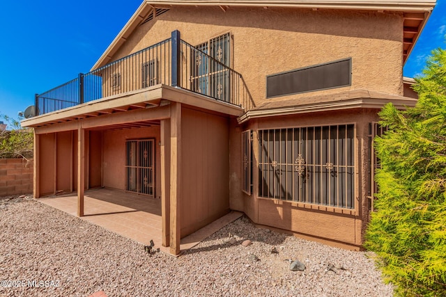 back of property featuring a patio area, fence, and stucco siding