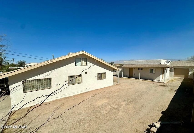 rear view of house with stucco siding