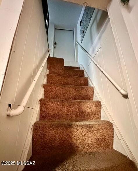 stairs featuring a decorative wall