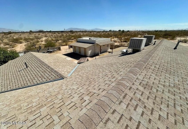 exterior space featuring a mountain view and a shingled roof