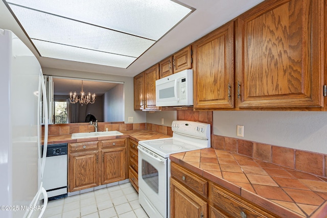 kitchen featuring tile countertops, white appliances, brown cabinets, and a sink