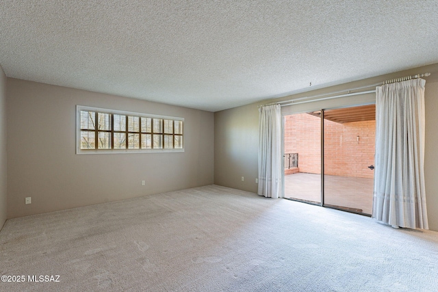 carpeted spare room with a textured ceiling