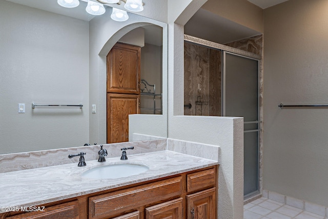 bathroom with tile patterned floors, baseboards, vanity, and a shower stall